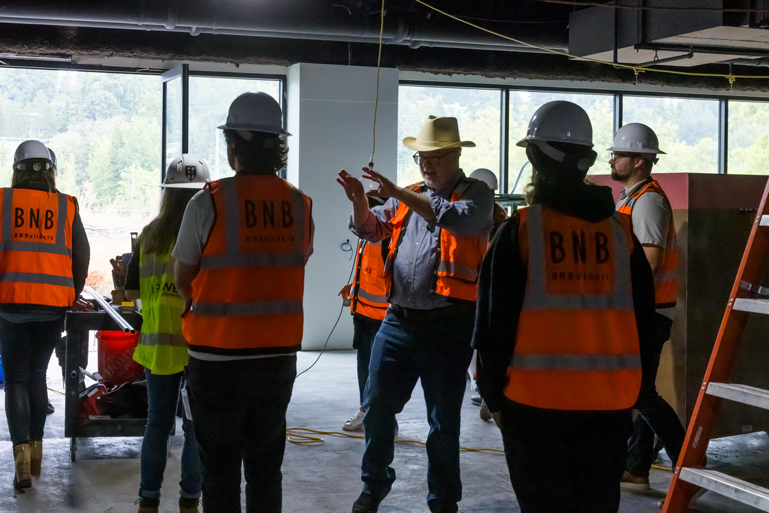 Joseph, sporting his signature cowboy hard hat, takes a team through a tour of the office in progress